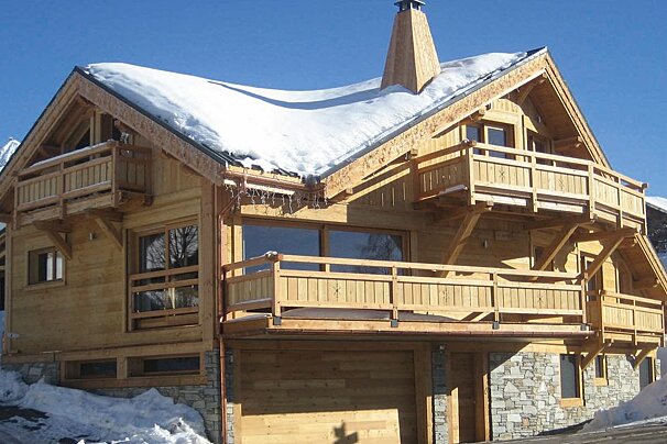 A large wooden house with snow on the roof