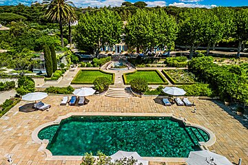 An aerial view of a large swimming pool surrounded by chairs and umbrellas