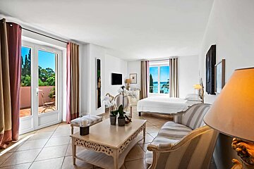 A hotel room with a couch and a table