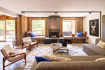 A living room with a fireplace and a picture of a deer on the wall