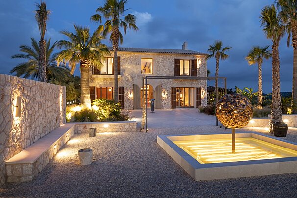 A stone house with palm trees in front of it