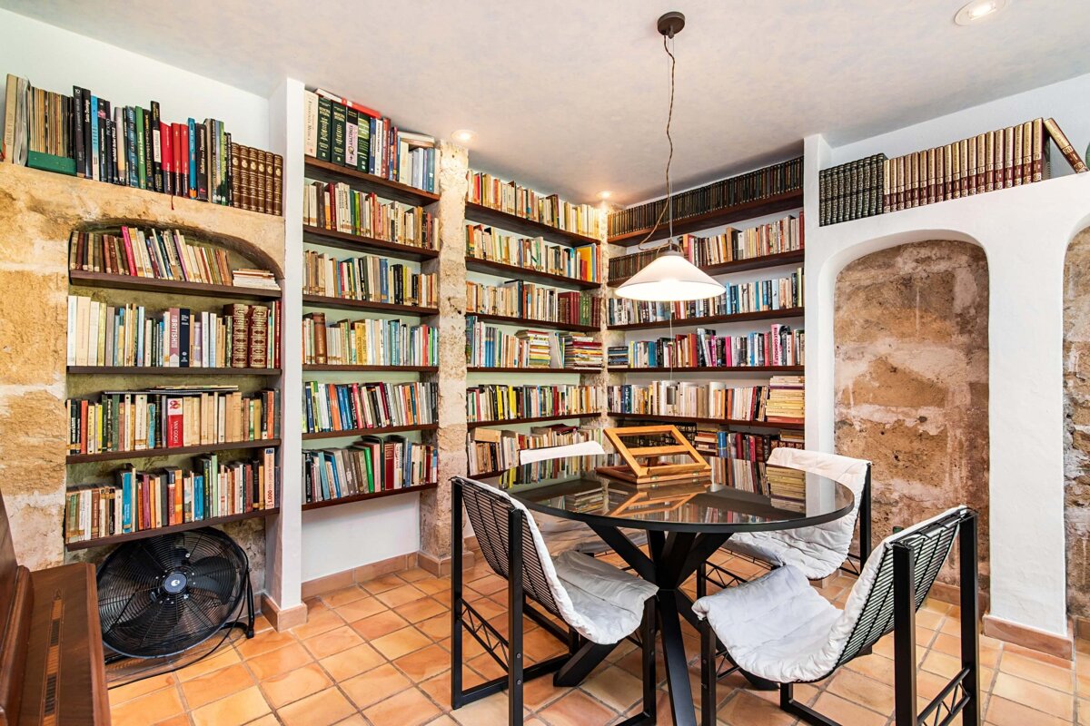 A library with a table and chairs and a fan