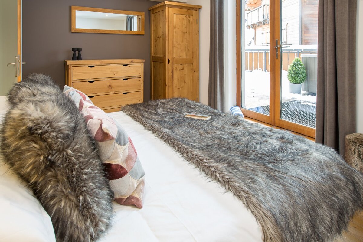 A bedroom with a fur blanket on the bed