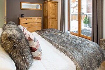 A bedroom with a fur blanket on the bed
