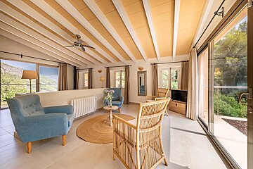 A living room with two chairs and a ceiling fan