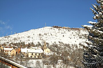 A snowy mountain with a church on top of it
