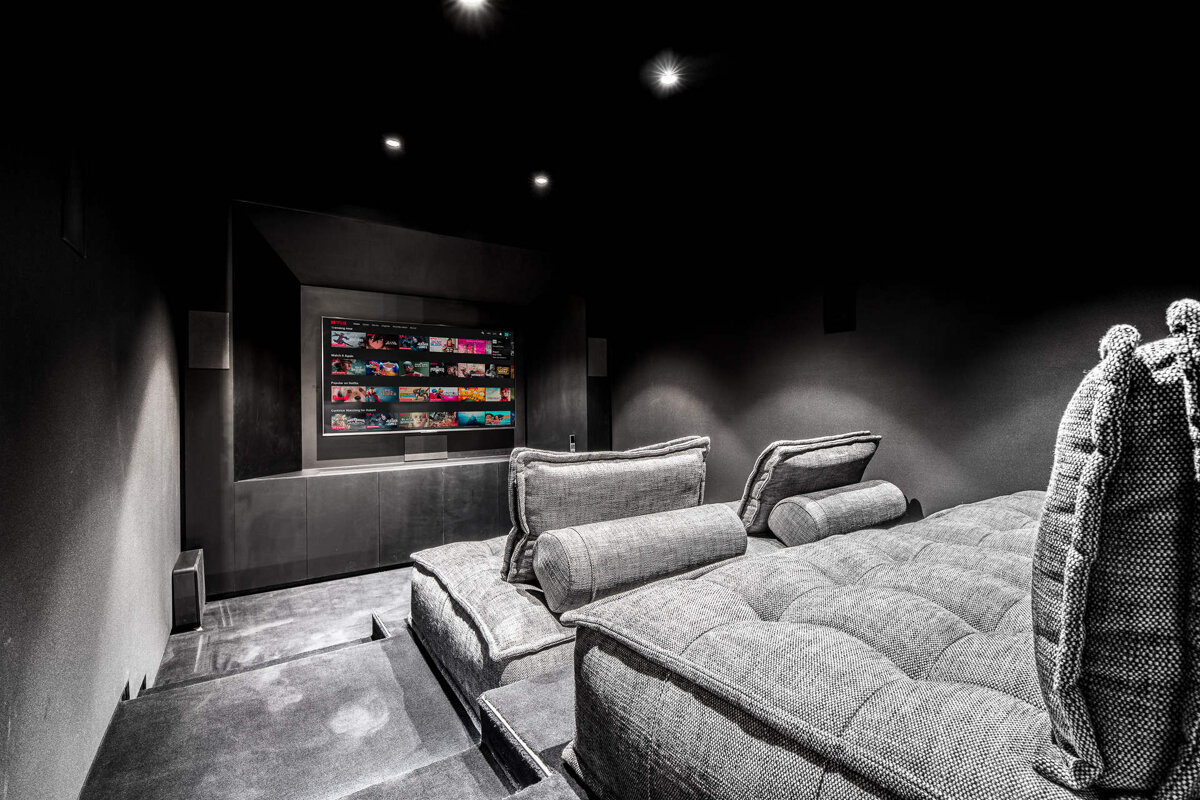 A couch in a dark room with a netflix screen behind it