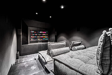 A couch in a dark room with a netflix screen behind it