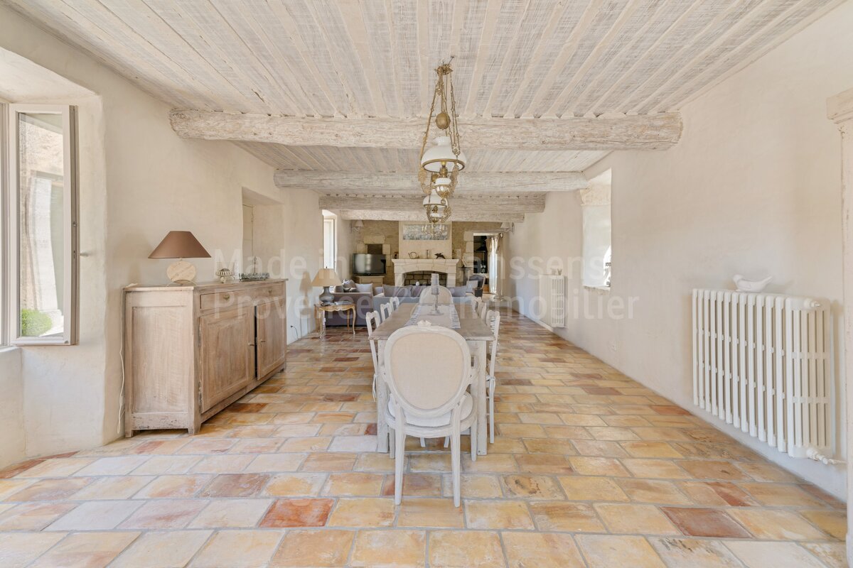A dining room with a table and chairs and a sign that says made by provence immobilier
