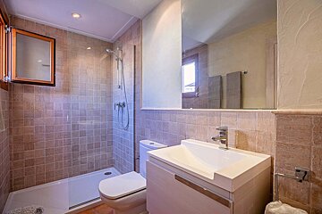 A bathroom with a toilet a sink and a shower