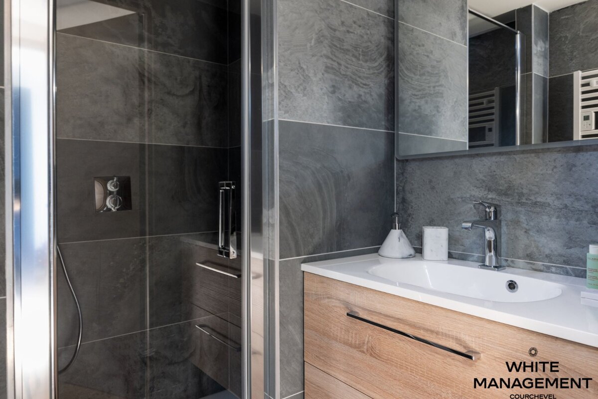 A bathroom with a rental designer logo on the corner