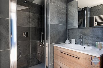 A bathroom with a rental designer logo on the corner