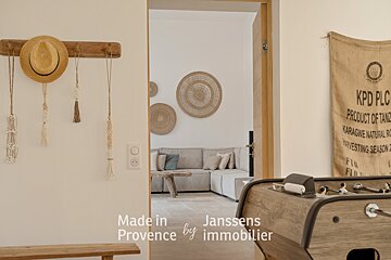 A room with a couch and a table with the words made in provence by immobilier