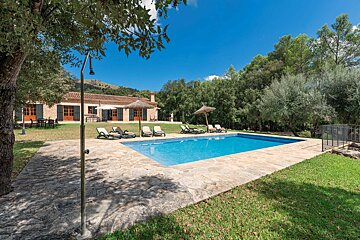 A large swimming pool in front of a house