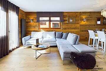 A living room with white management written on the bottom
