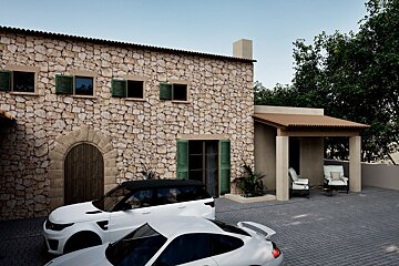 A white car is parked in front of a stone building