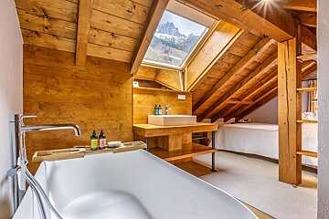 A bathroom with a bathtub a sink and a skylight