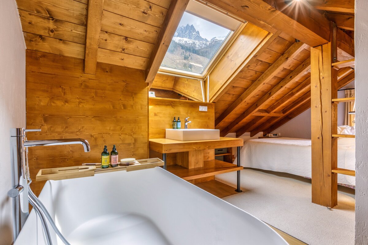 A bathroom with a bathtub a sink and a skylight
