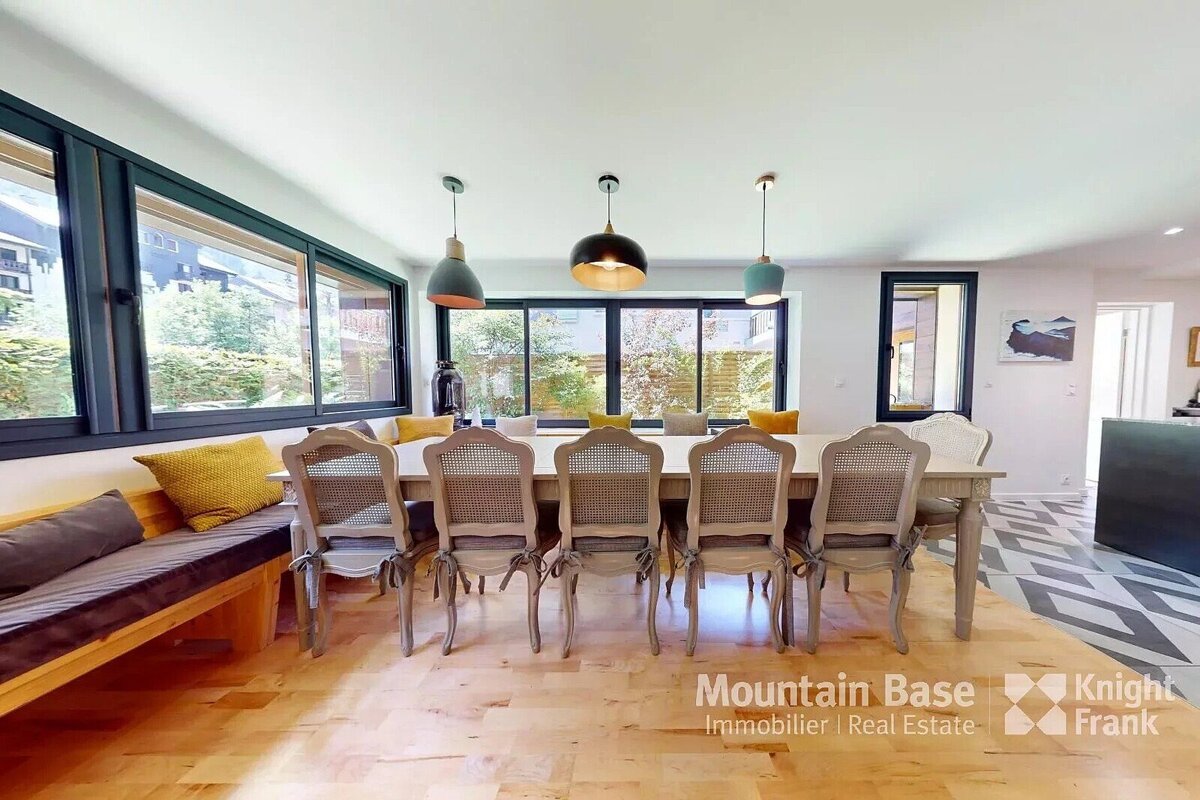 A dining room with a table and chairs from mountain base