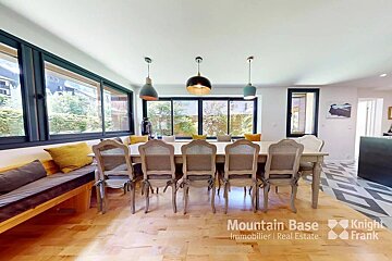 A dining room with a table and chairs from mountain base