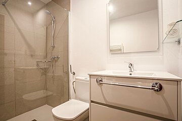 A bathroom with a toilet a sink and a mirror