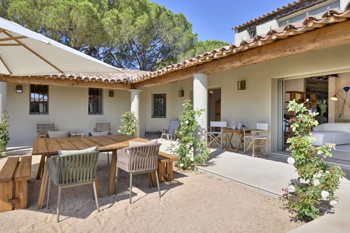 A patio with a table and chairs under an umbrella