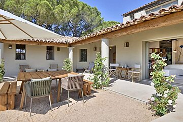 A patio with a table and chairs under an umbrella