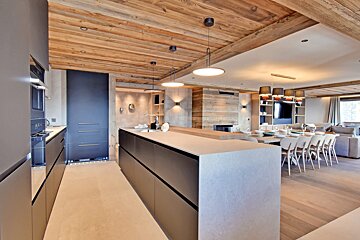 A kitchen with a wooden ceiling and black cabinets