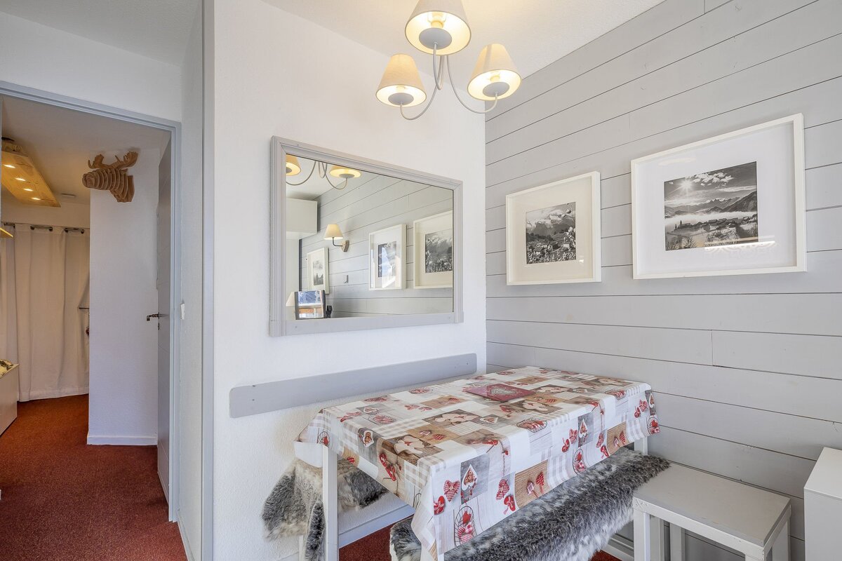 A room with a table and a mirror on the wall