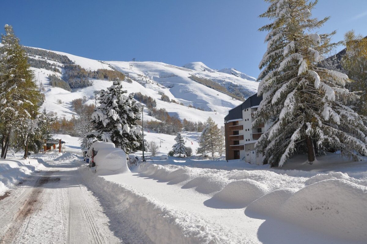 A snowy landscape with a building in the background