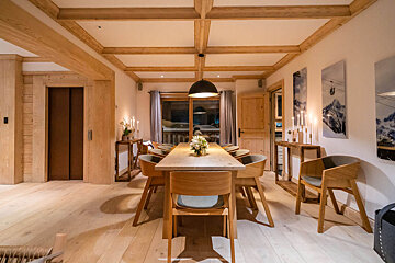A dining room with a long wooden table and chairs