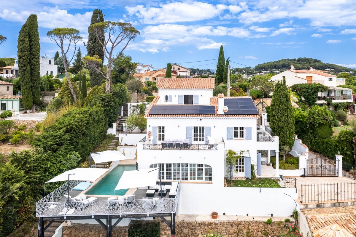 A large white house with solar panels on the roof