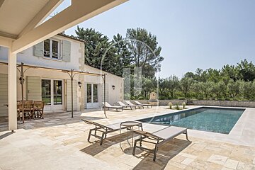 A house with a large swimming pool in front of it