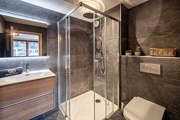 A bathroom with a walk in shower and a toilet
