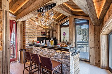A kitchen with a wooden ceiling and a bar