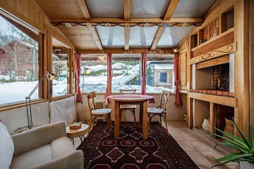 A room with a table and chairs and a fireplace