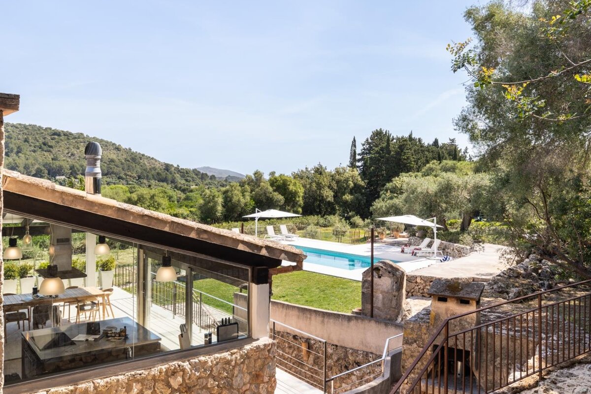 A large swimming pool is surrounded by trees and mountains