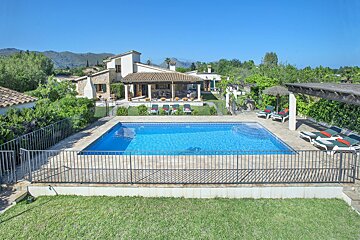 A large swimming pool in front of a house