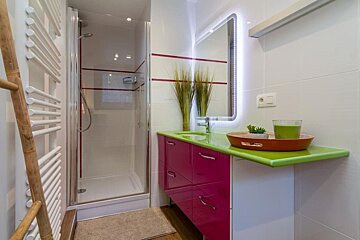 A bathroom with pink cabinets and a green counter top