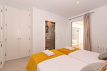 A bedroom with two beds and a sliding glass door
