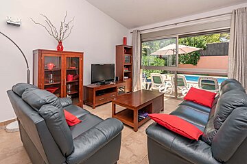 A living room with black leather couches and a flat screen tv