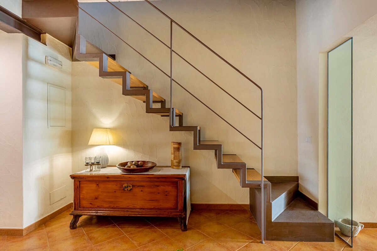 A staircase with a wooden dresser underneath it