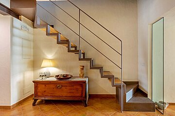 A staircase with a wooden dresser underneath it