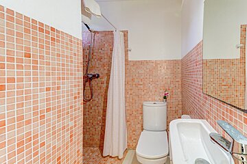 A bathroom with a toilet a sink and a shower