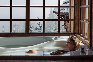 A woman is taking a bath in front of a window