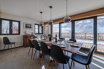 A dining room with a large table and chairs