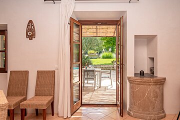 A door open to a patio with a table and chairs
