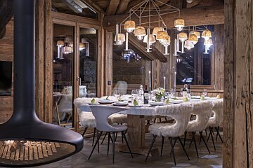 A dining room with a table and chairs and a fireplace