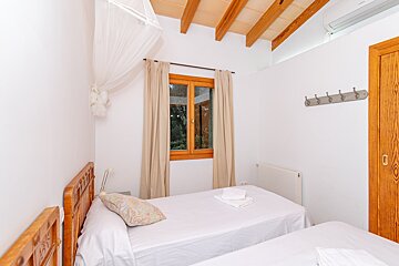 A bedroom with two twin beds and a window