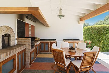A patio with a table and chairs and a lantern hanging from the ceiling
